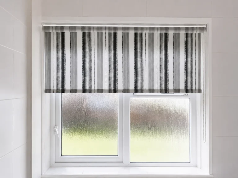 Striped roller blind fitted to a frosted bathroom window.